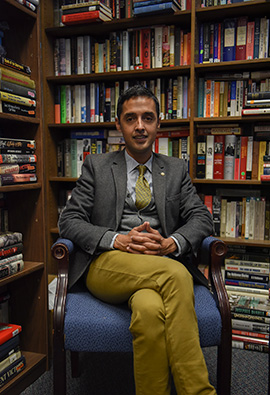 Anand Toprani sitting in front of books