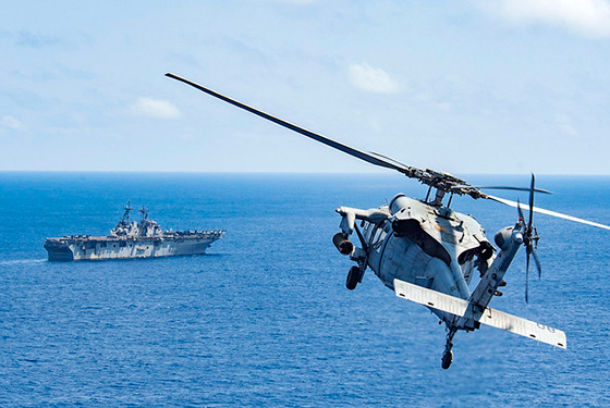 An MH-60S Sea Hawk attached to Helicopter Sea Combat Squadron 25 (HSC-25) approaches the amphibious assault ship USS Wasp (LHD 1).