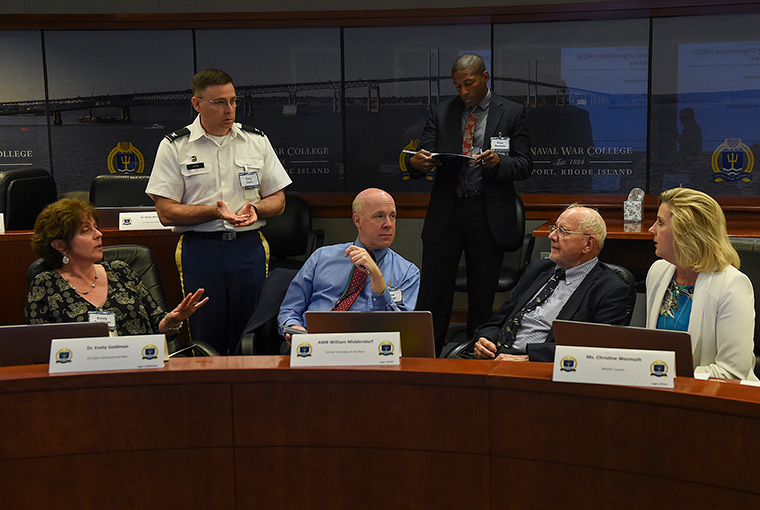 Participants discuss an evolving situation as part of the Navy-Private Sector Critical Infrastructure Wargame held at U.S. Naval War College, Newport, Rhode Island. 