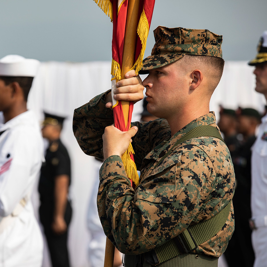 U.S. Marine Corps Sgt. Jeremy Hill carries the U.S. Marine Corps colors during the exercise Tiger TRIUMPH opening ceremony aboard the Indian navy amphibious transport dock ship INS Jalashwa (L41) in Visakhapatnam, India, Nov. 14, 2019.