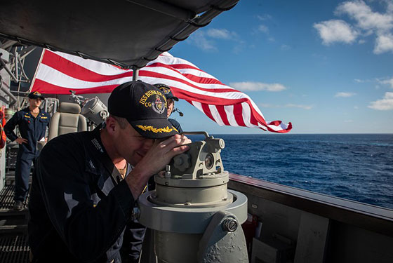 Capt. Kurt Sellerburg, commanding officer of the Ticonderoga-class guided-missile cruiser USS Bunker Hill (CG 52), uses a telescopic alidade to take a bearing to a surface contact, Jan. 25, 2020.