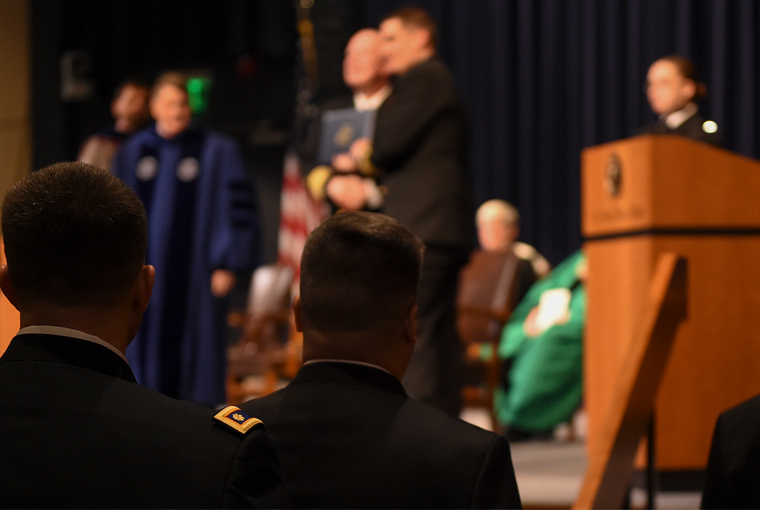 U.S. Naval War College (NWC) students wait for their names to be called during their graduation ceremony held at NWC in Newport, Rhode Island.