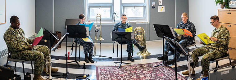 Members of Navy Band Northeast’s (NBNE) Brass Quintet: Musician 2nd Class Brandon Britt (left), Musician 2nd Class Loralee Swanson, Musician 2nd Class Connor Hailey, Musician 2nd Class Christopher Hess, and Musician 2nd Class Edward Reid read various letters sent to them from 5th graders at Agnes Little Elementary School in Pawtucket, Rhode Island. 