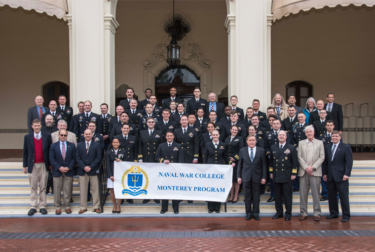 Photo of the 74th graduating class of the U.S. Naval War College Monterey program for joint professional military education standing on the steps of Naval Postgraduate School’s Herrmann Hall. 