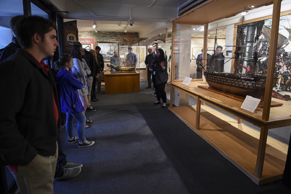 Liz DeLucia, director of education and public outreach, U.S. Naval War College Museum, gives students from Portsmouth High School and local military veterans a tour at the museum on Monday, May 15.