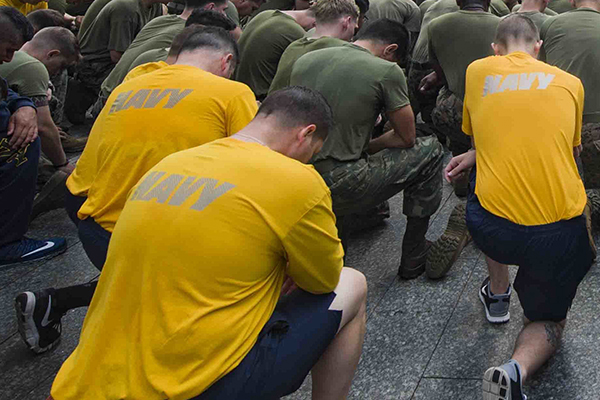 Sailors and Marines kneel
