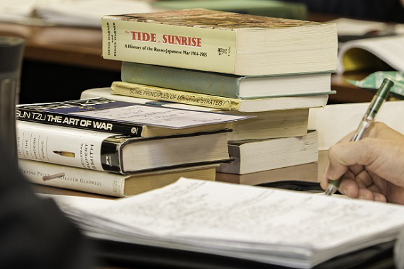 Books on a desk with student